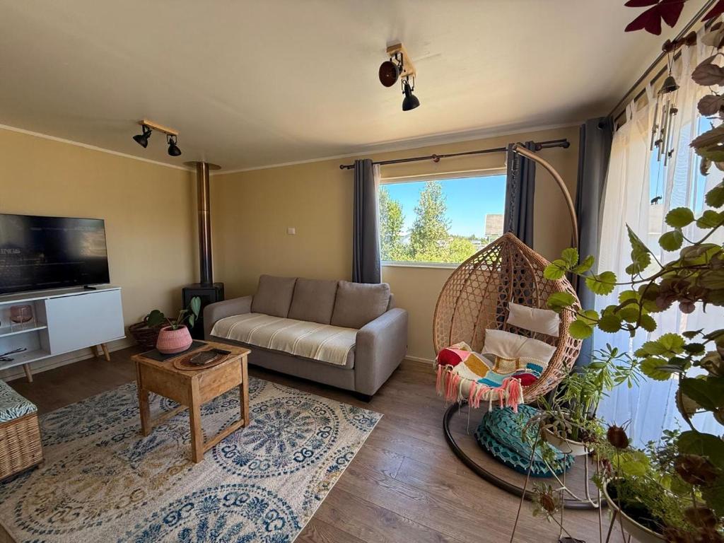 een woonkamer met een bank en een schommel bij Acogedora Casa Los Canelos in Puerto Varas
