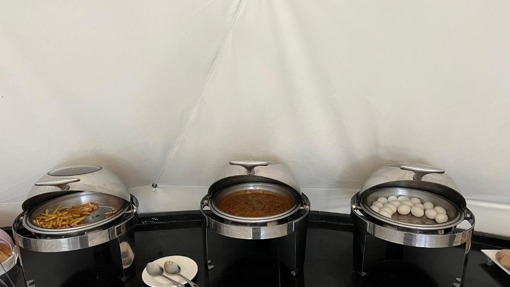three pots of food on a counter in a kitchen at RUM NADINE LUXURY CAMP & Bubbles Hotel in Wadi Rum