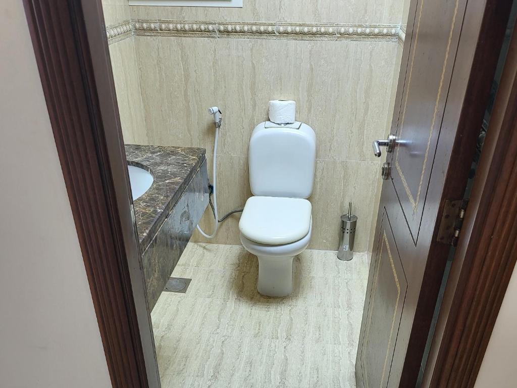 un bagno con un water bianco e un lavandino di SeaViewApartment a Salalah