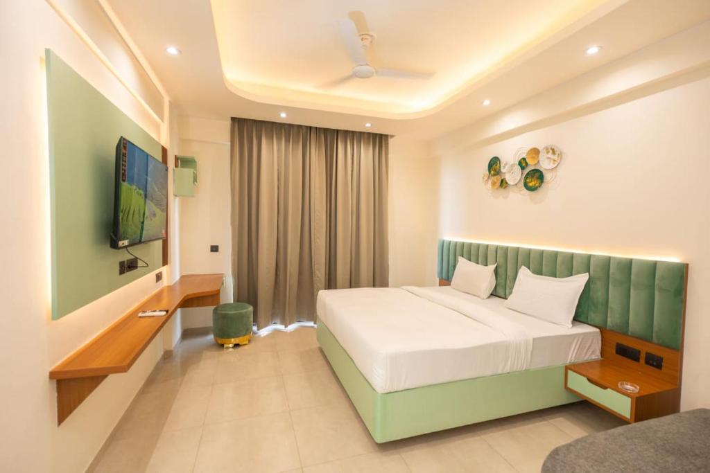 a hotel room with a bed and a television at Celestia Grand in Lucknow