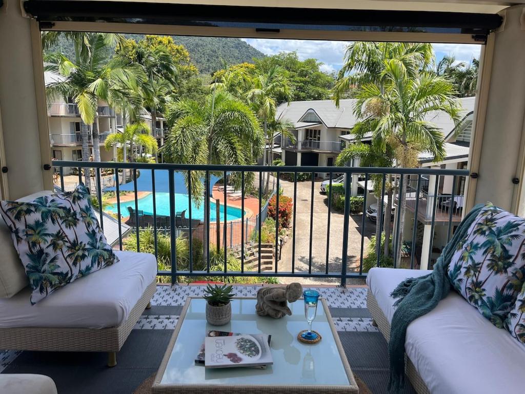a living room with a balcony with a view of a pool at Beach Road Bliss- Whitsundays in Cannonvale
