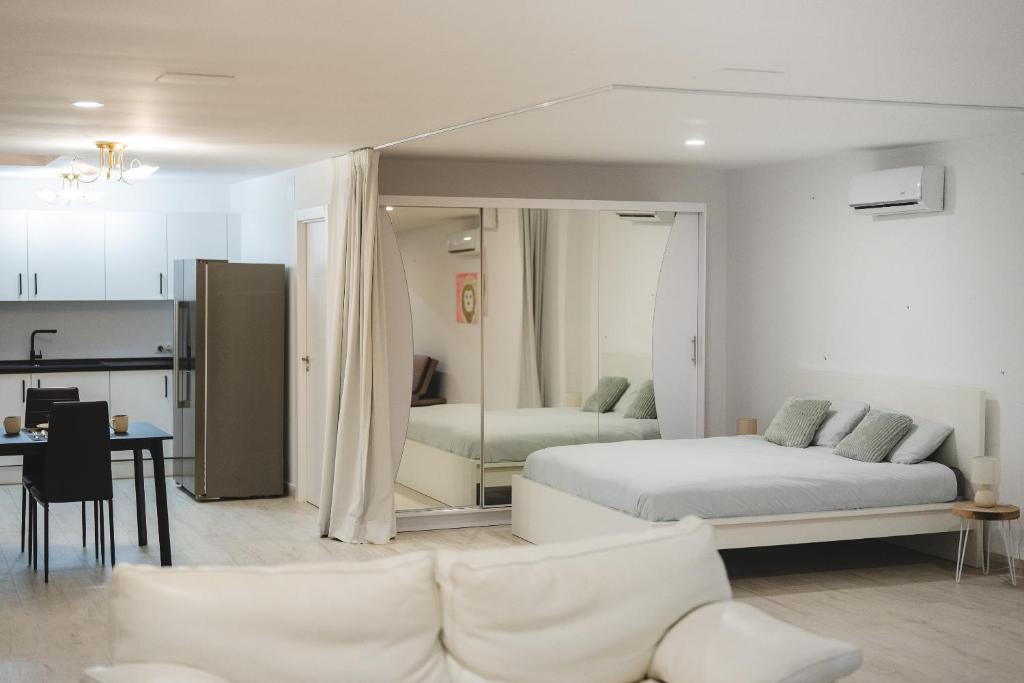 een woonkamer met een bed en een keuken bij New - MiJa basement Loft Apartment steps from Beach - perfect for Sun and Sport Seekers in Marbella