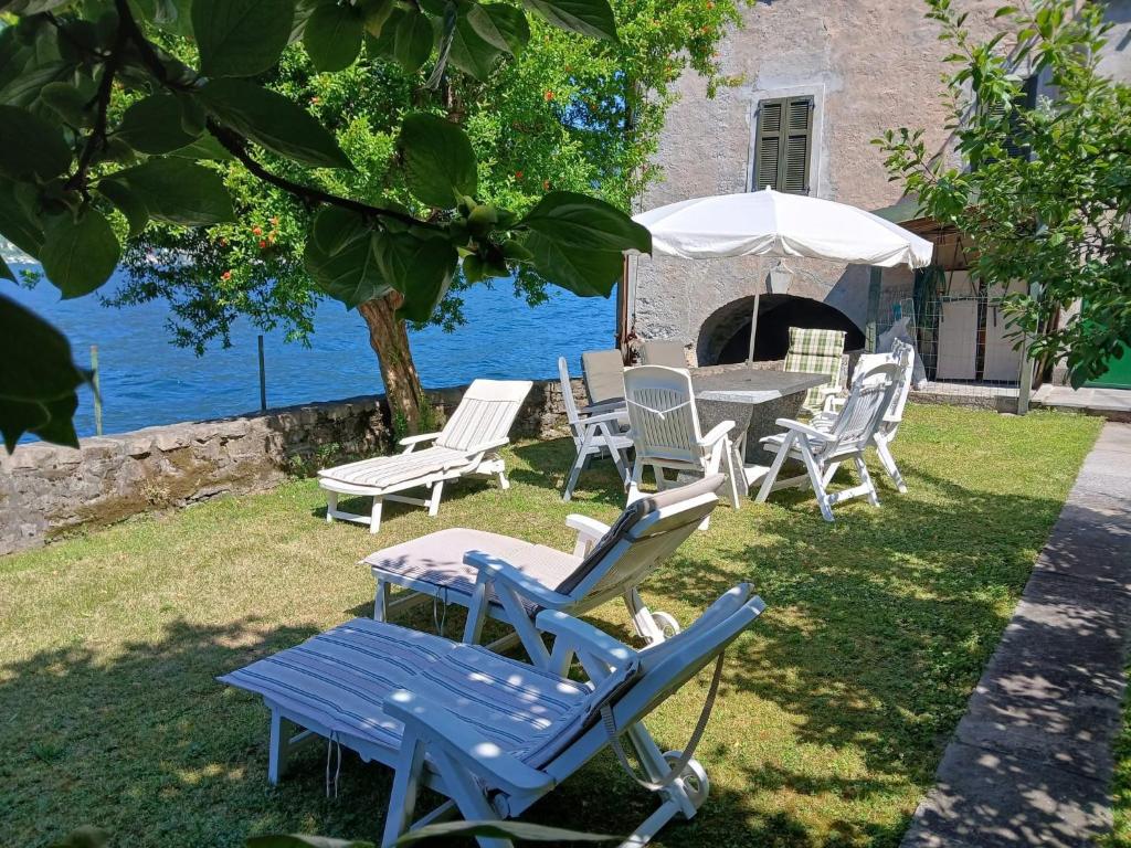 a group of chairs and a table with an umbrella at La casa di Mimo in Nesso