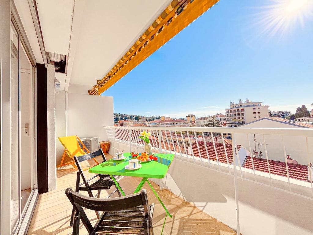a green table and chairs on a balcony at Cannes Montfleury - Comfortable accommodation Center in Cannes