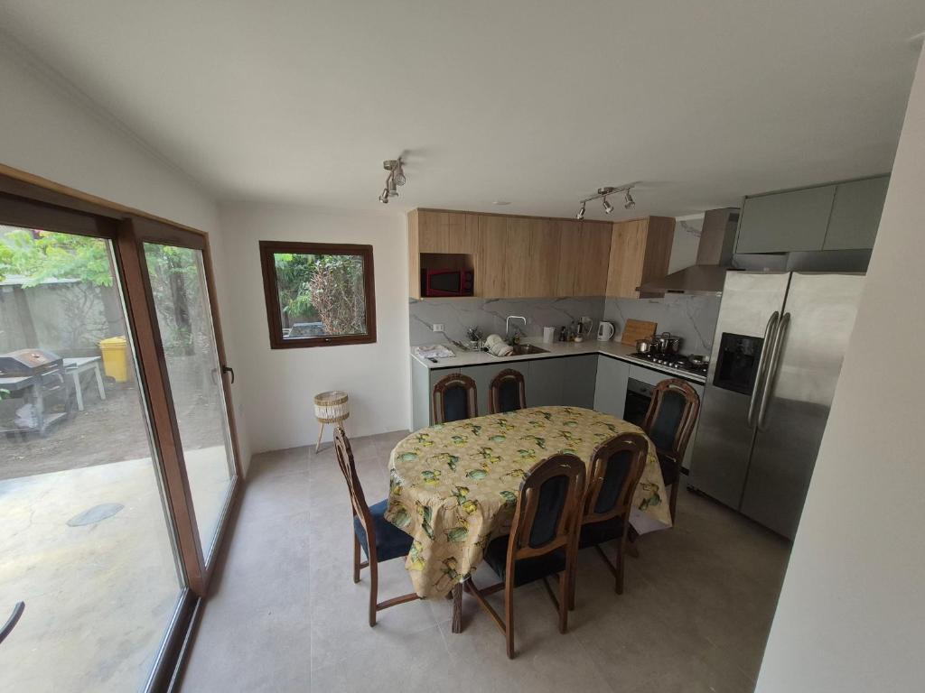 een keuken met een tafel en stoelen en een keuken met een koelkast bij Casa Lidia in Viña del Mar