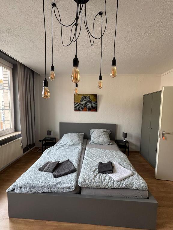 two beds in a bedroom with lights hanging from the ceiling at DoubleRoom shared house 1 floor in Linz am Rhein