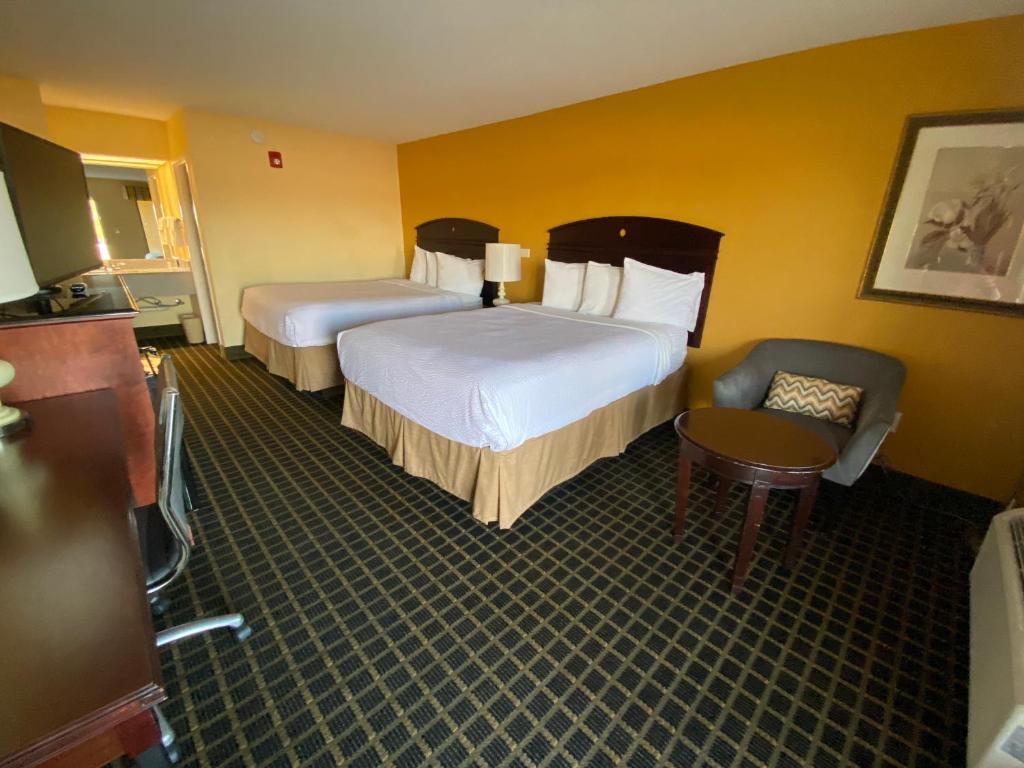 a hotel room with two beds and a chair at Travelinn in Unadilla