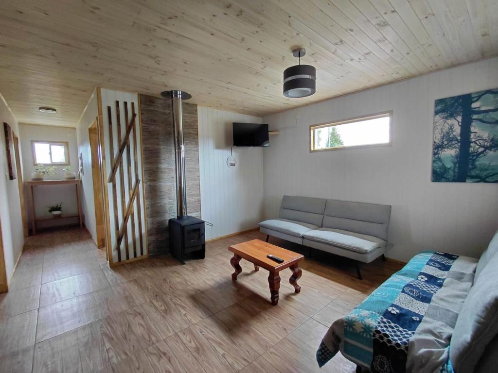 a living room with a couch and a table at Cabaña 3 Aeropuerto el Tepual in Puerto Montt