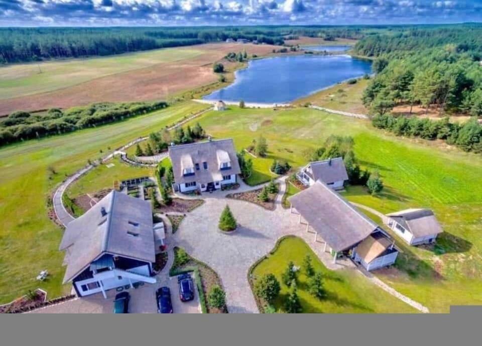 an aerial view of a large house with a lake at Farma Noe - Agroturystyka in Lipnica