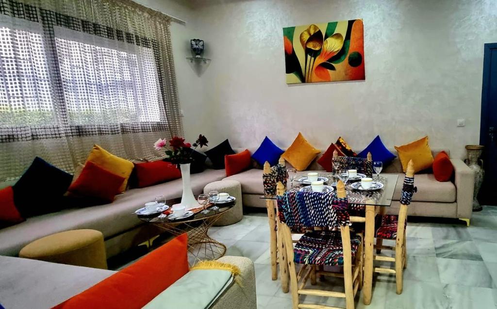a living room with a couch and a table at Appart Ennakhil 4 avenue mohamed 6 in El Jadida