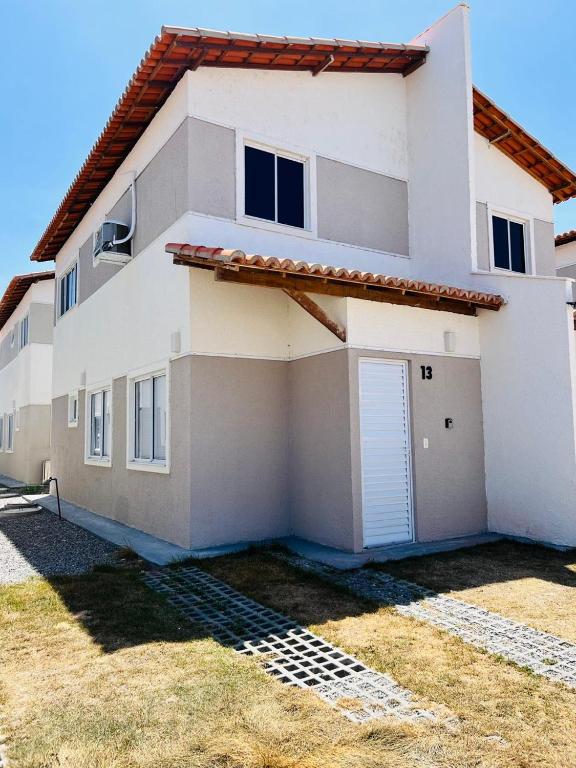 a white house with a garage at Casa duplex em condomínio Parnaiba in Parnaíba