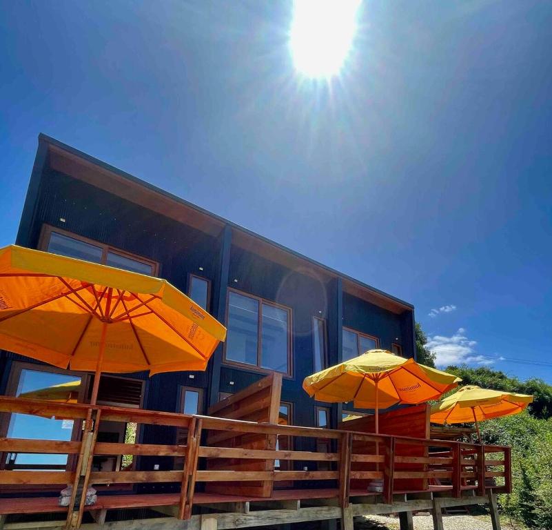 zwei orangefarbene Regenschirme vor einem Gebäude in der Unterkunft Loft Valdivia - cutipay in Valdivia