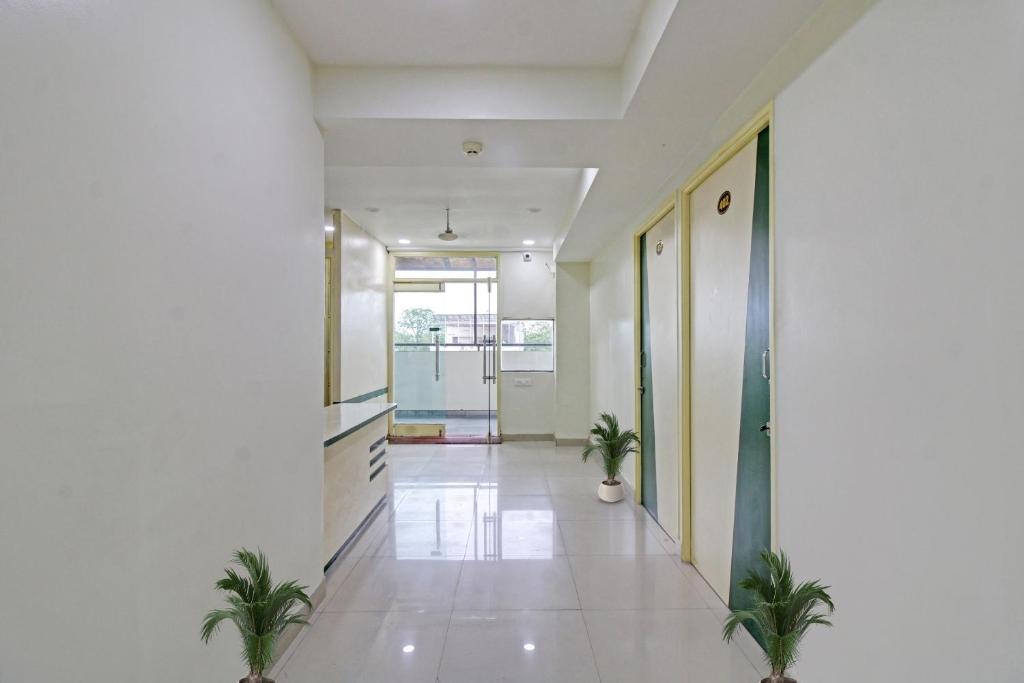un couloir vide avec des plantes en pot dans un bâtiment dans l'établissement Hotel O Sunshine Inn, à Nagpur