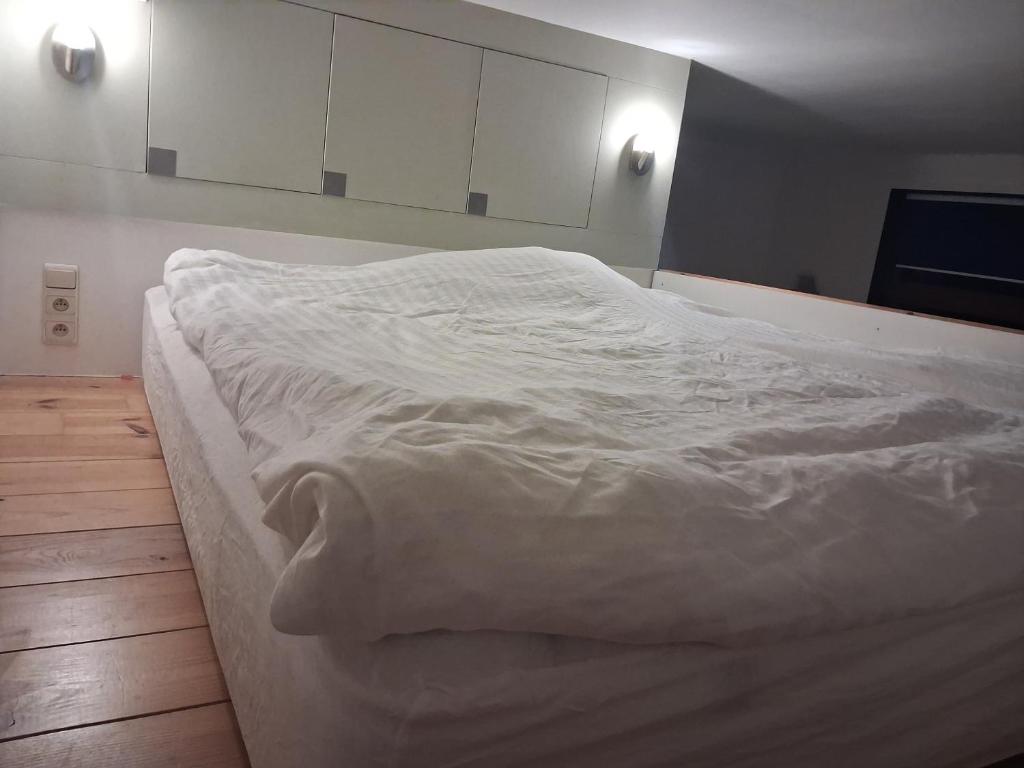 a large white bed in a room with white cabinets at Apart studio3 in Kortenberg