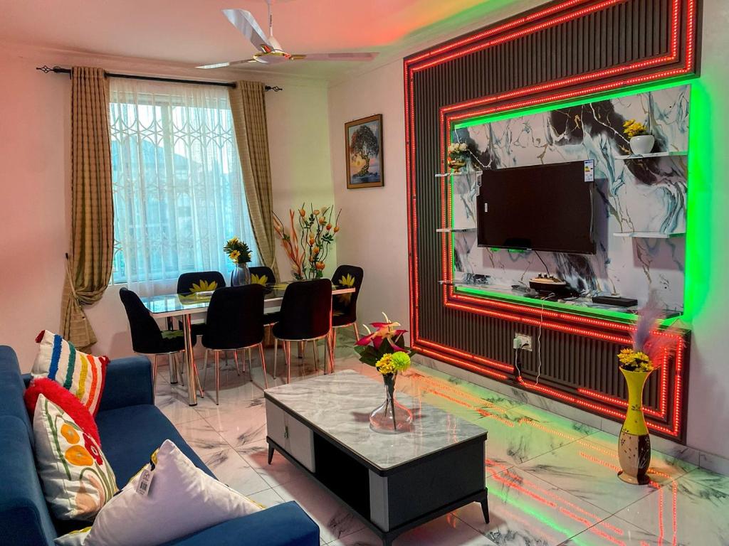 ein Wohnzimmer mit einer blauen Couch und einem Fernseher in der Unterkunft Somerset Apartmento in Tokuse