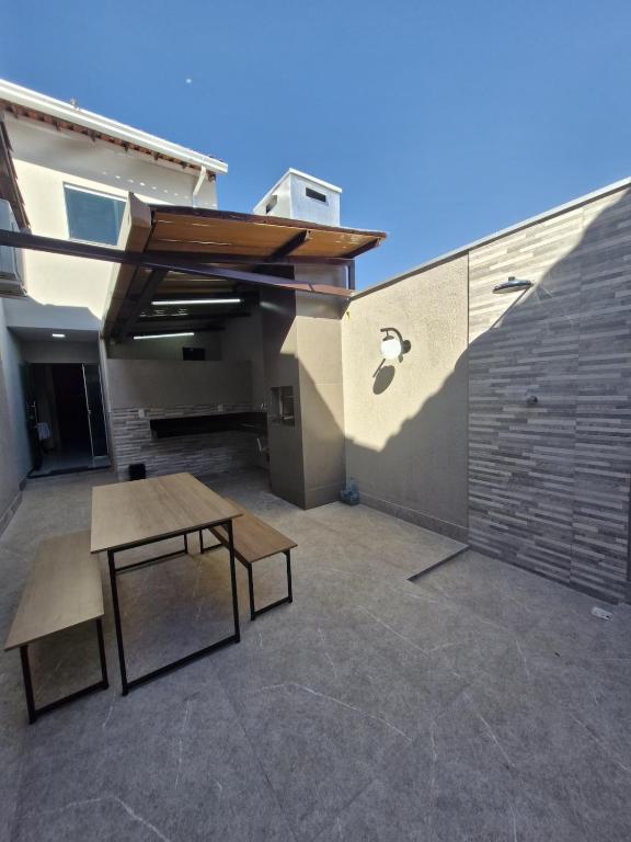 a patio with a table and a bench and a building at loft climatizado em Timóteo próximo à Aperam, Ipatinga e Coronel Fabriciano in Timóteo