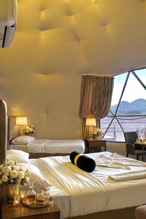 a hotel room with two beds and a large window at Rum Horizon camp & Jeep Tours in Wadi Rum