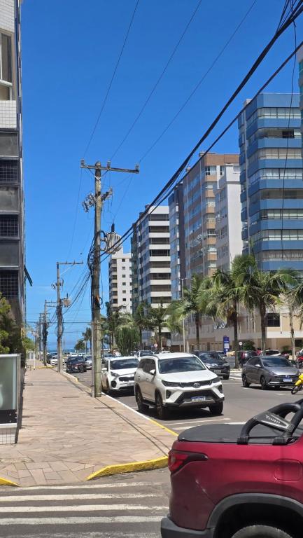 a busy city street with cars parked on the street at Dona Iva in Capão da Canoa