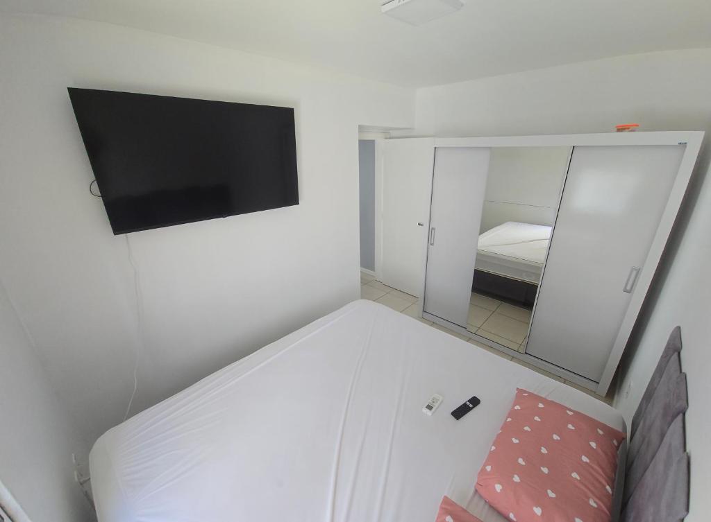 een kamer met een spiegel en een tv aan de muur bij Dona Iva in Capão da Canoa