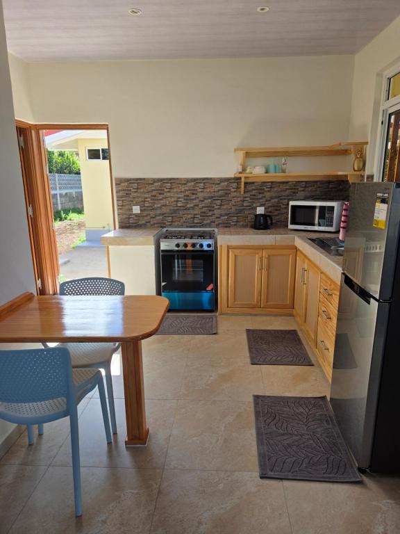 a kitchen with a table and a refrigerator at AK Lodge Raiatea in Raiatea