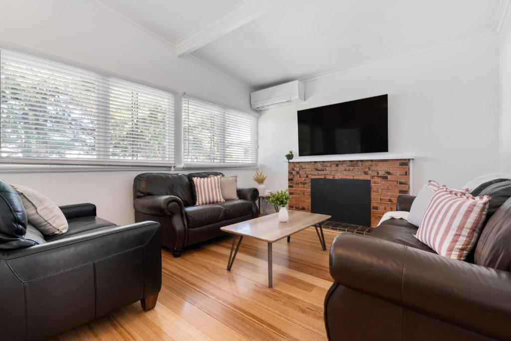 a living room with two couches and a fireplace at The Ocean Gem at Rosebud with its own Private Beach Box in Rosebud