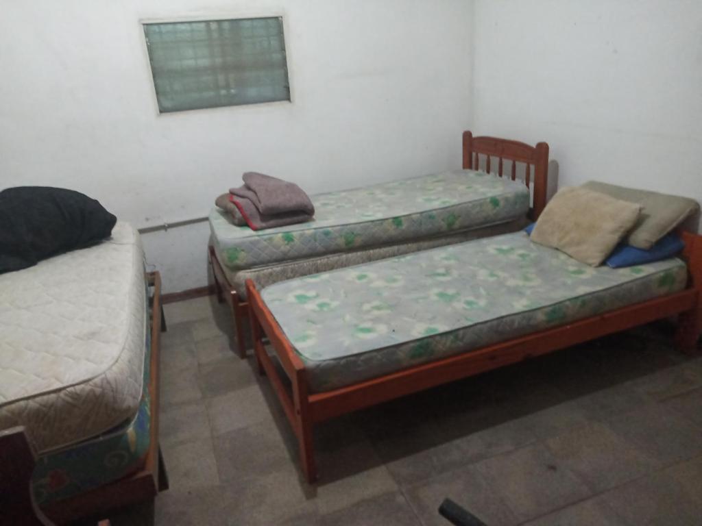 een kamer met drie bedden in een kamer bij Quinta con pileta Las Acacias in Paraná