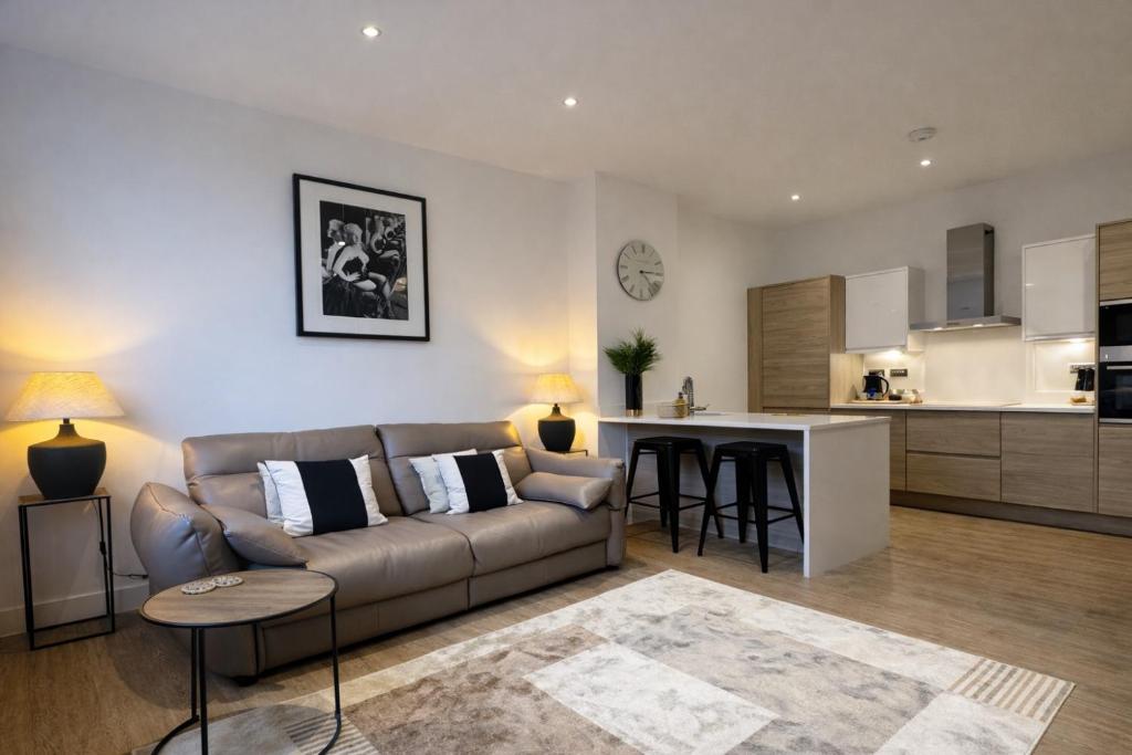 een woonkamer met een bank en een keuken bij Chester's - Central Chester Stays - 2 Cuppin Street - 2 Minute Walk From Shops in Chester