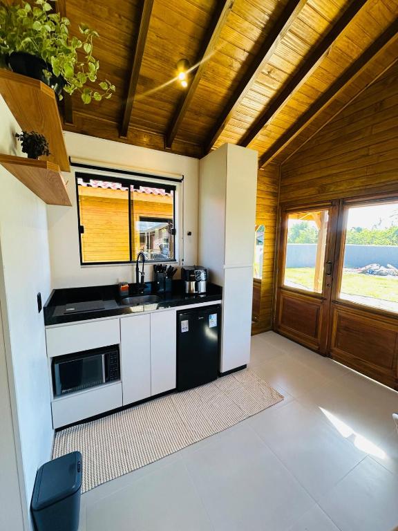 a kitchen with a sink and a stove at Cabana Raiz & Mar - 01 in Imbituba