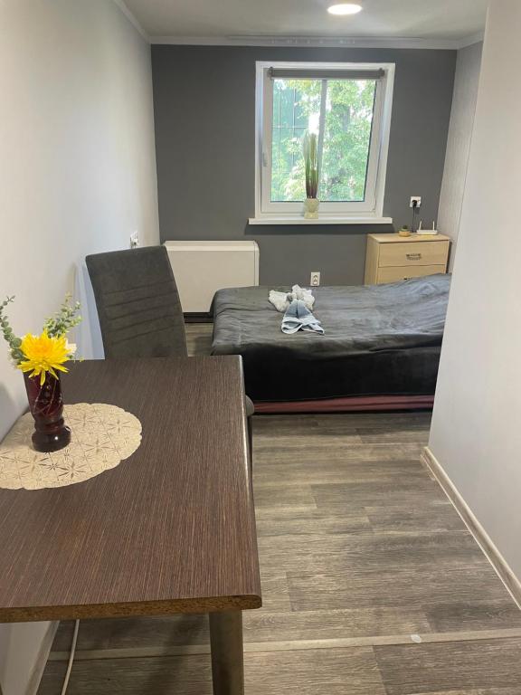 Cette chambre comprend une table et un lit avec une fenêtre. dans l'établissement Apartament Norwida przy Parku, à Jelenia Góra