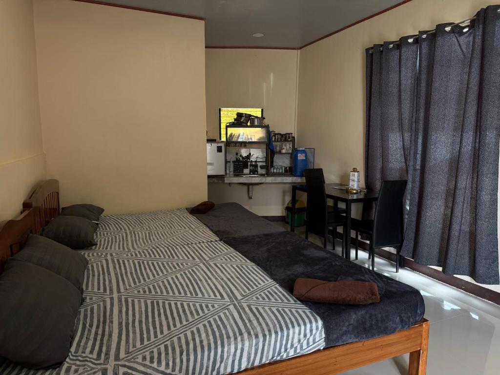 een slaapkamer met een bed en een tafel en een keuken bij R&C Transient Extension in El Nido