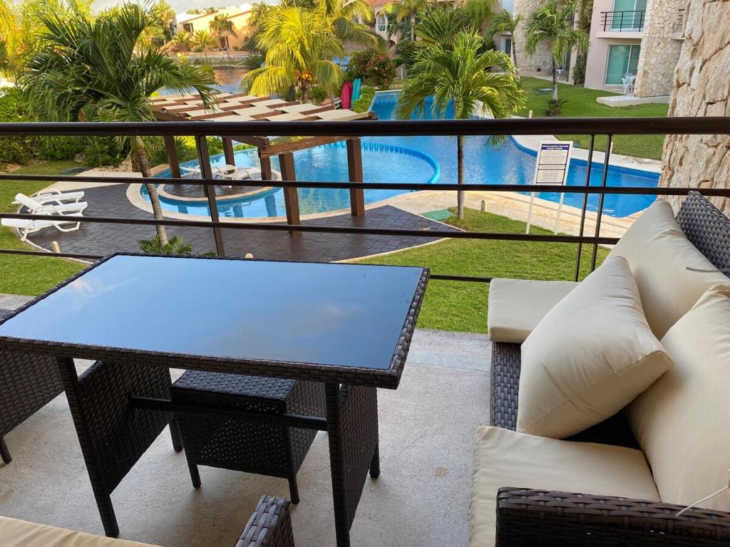 a balcony with a table and chairs and a pool at Condo Riviera in Puerto Aventuras
