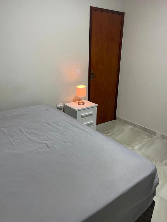 a bedroom with a bed and a lamp on a night stand at Ap Seabra 2 quartos in Seabra