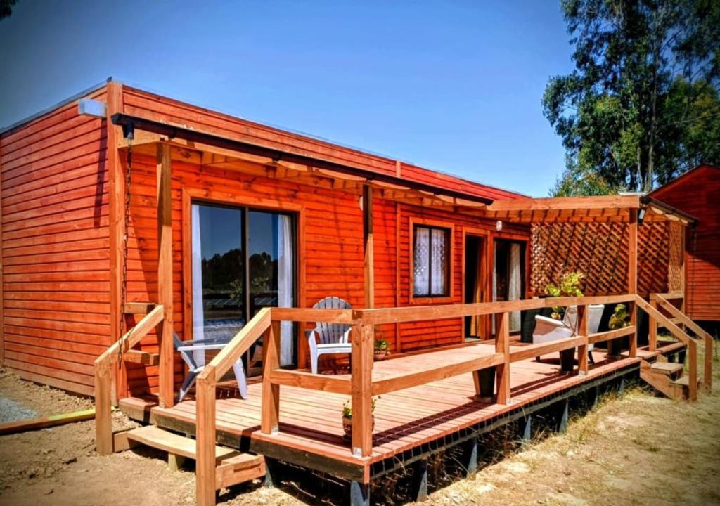 a wooden cabin with a porch and a deck at Cabaña Palmas de Tunquen in Tunquén