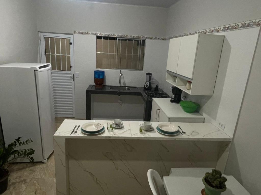 a small kitchen with a counter and a refrigerator at Casa da Villa Santa Rita in João Pessoa