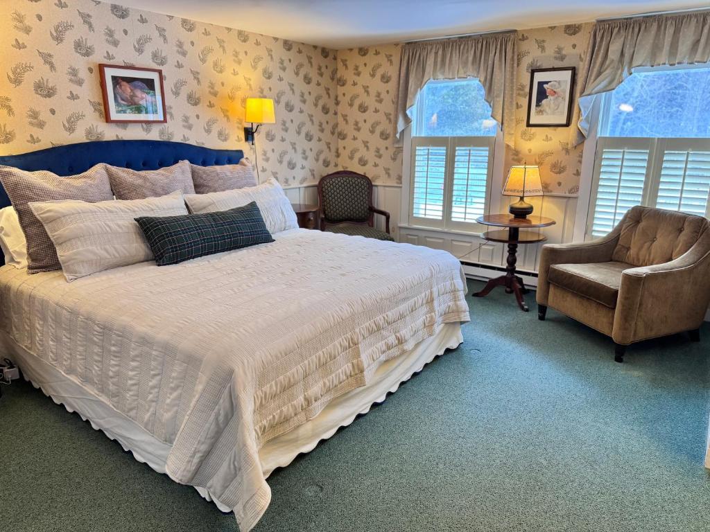 um quarto com uma cama grande e uma cadeira em The Landgrove em North Landgrove