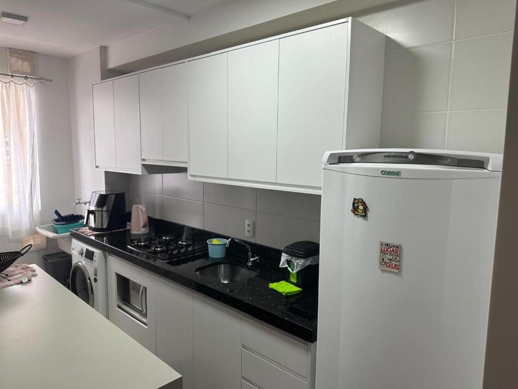 een witte keuken met een wastafel en een koelkast bij Aconchego Moro- Apto708, T-2 in Barra Velha