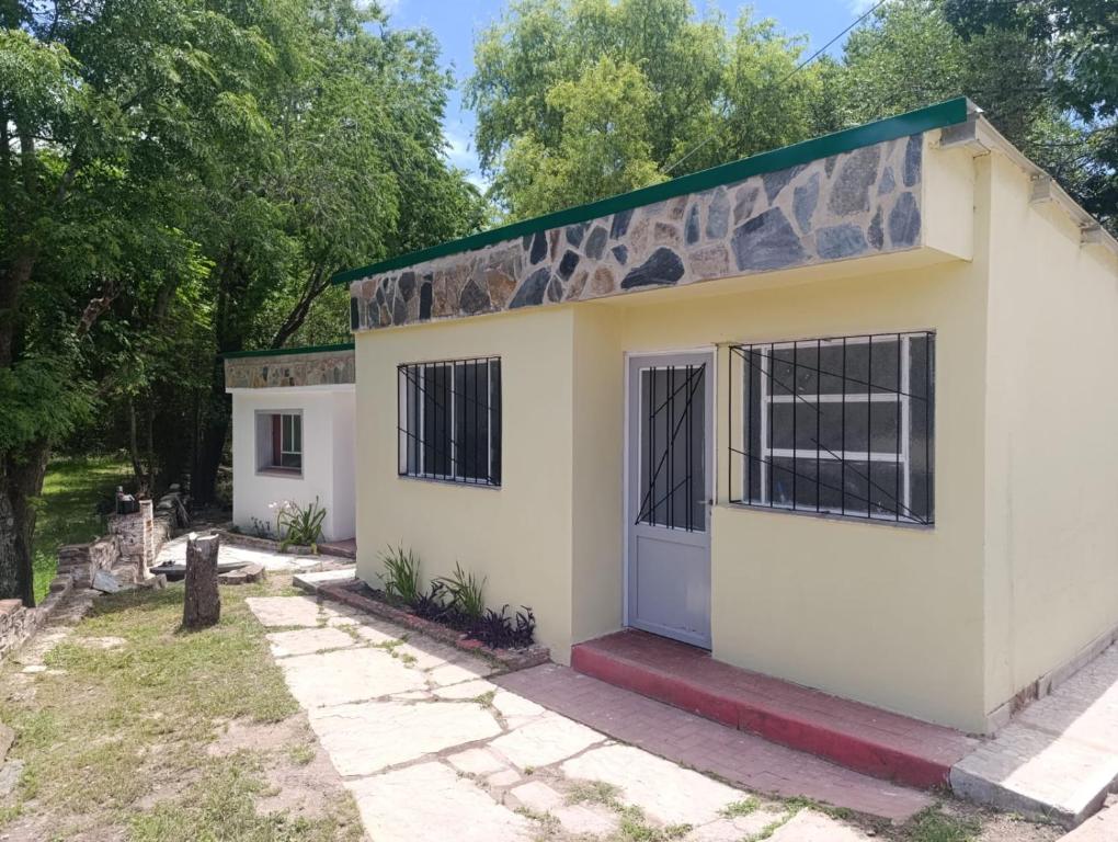 a small white house with a green roof at Las Vertientes in Tanti