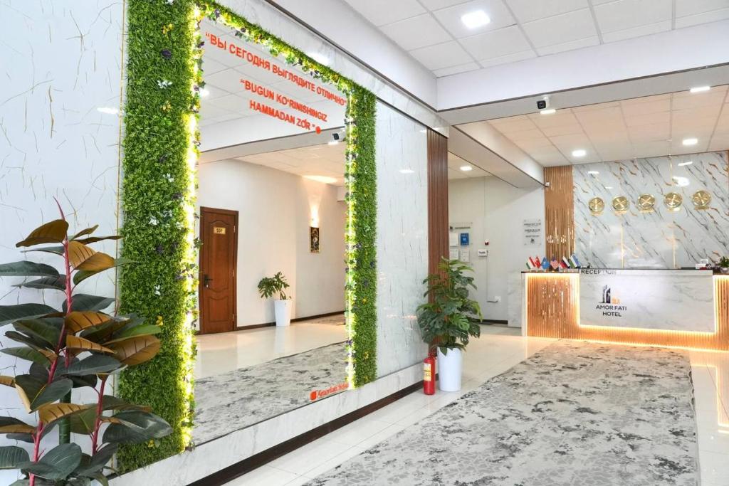 een kantoorlobby met een groene klimopmuur bij Amor Fati Hotel tashkent in Katartal