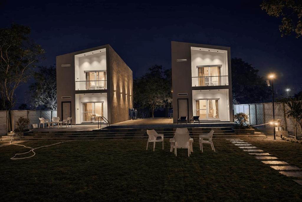 a building with chairs in front of it at night at Horizon vue Villas in Rājahmundry