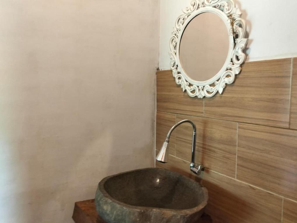 a bathroom with a large stone sink and a mirror at Bali namping in Petang