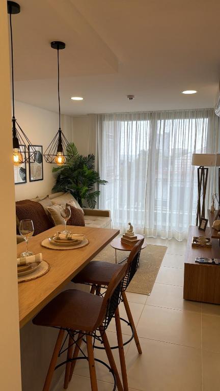 a kitchen and living room with a table and chairs at Lujoso Apartamento en edificio frente a la playa San José! in Encarnación