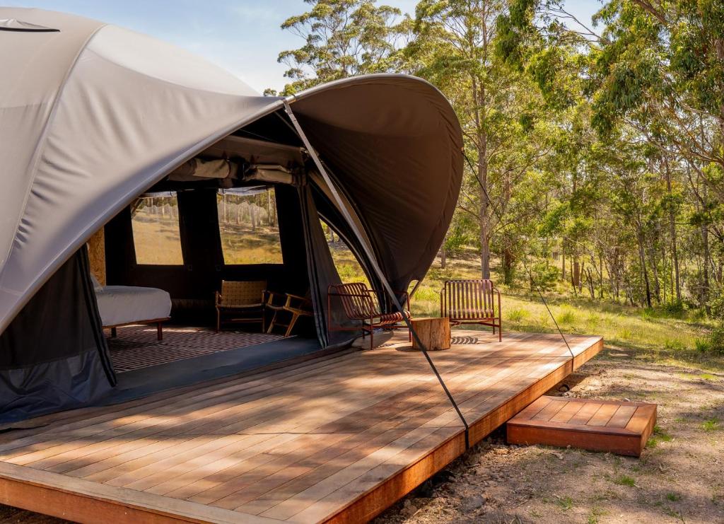 a tent with a wooden deck in a field at Mimosa Wines in Murrah