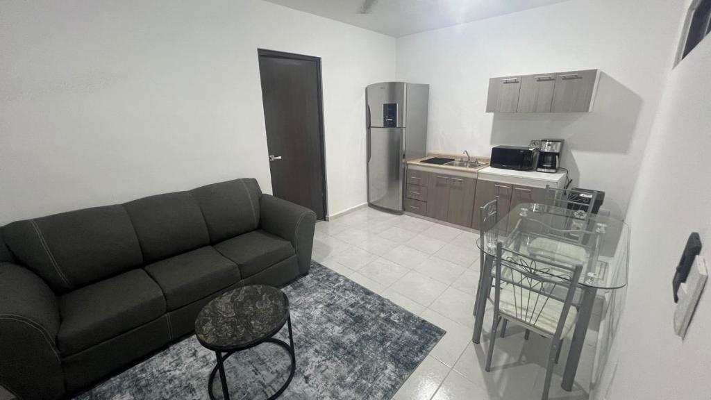 a living room with a couch and a kitchen at Departamento Liss in Mérida