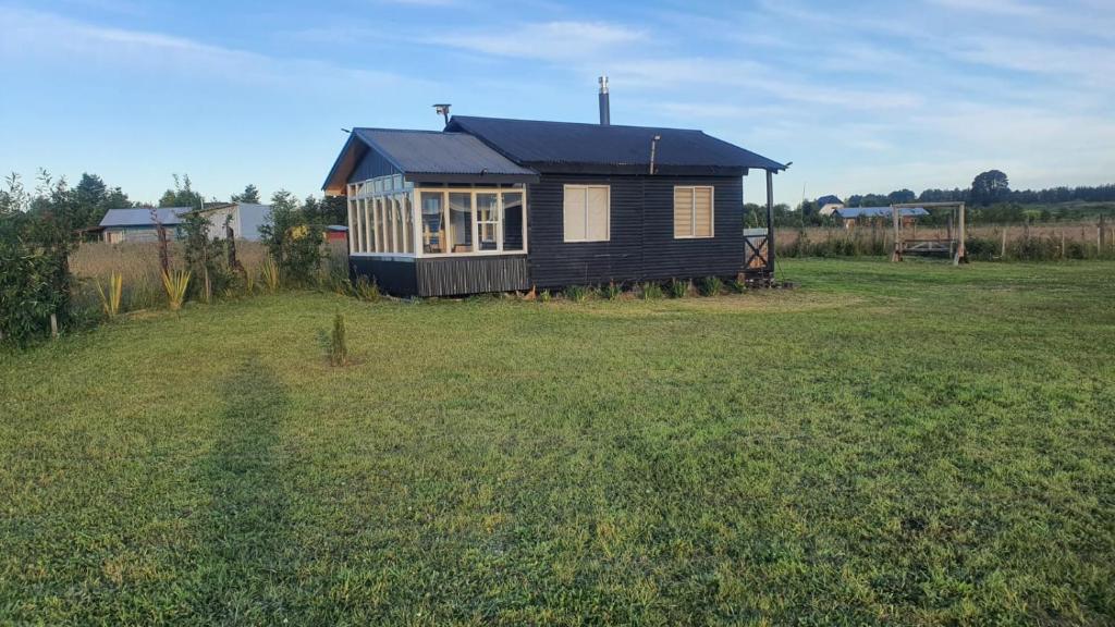 een klein huis in een grasveld bij Cabaña en Frutillar in Frutillar