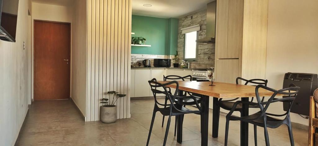 een keuken met een houten tafel en stoelen bij Departamentos Hilario Lagos in Viedma