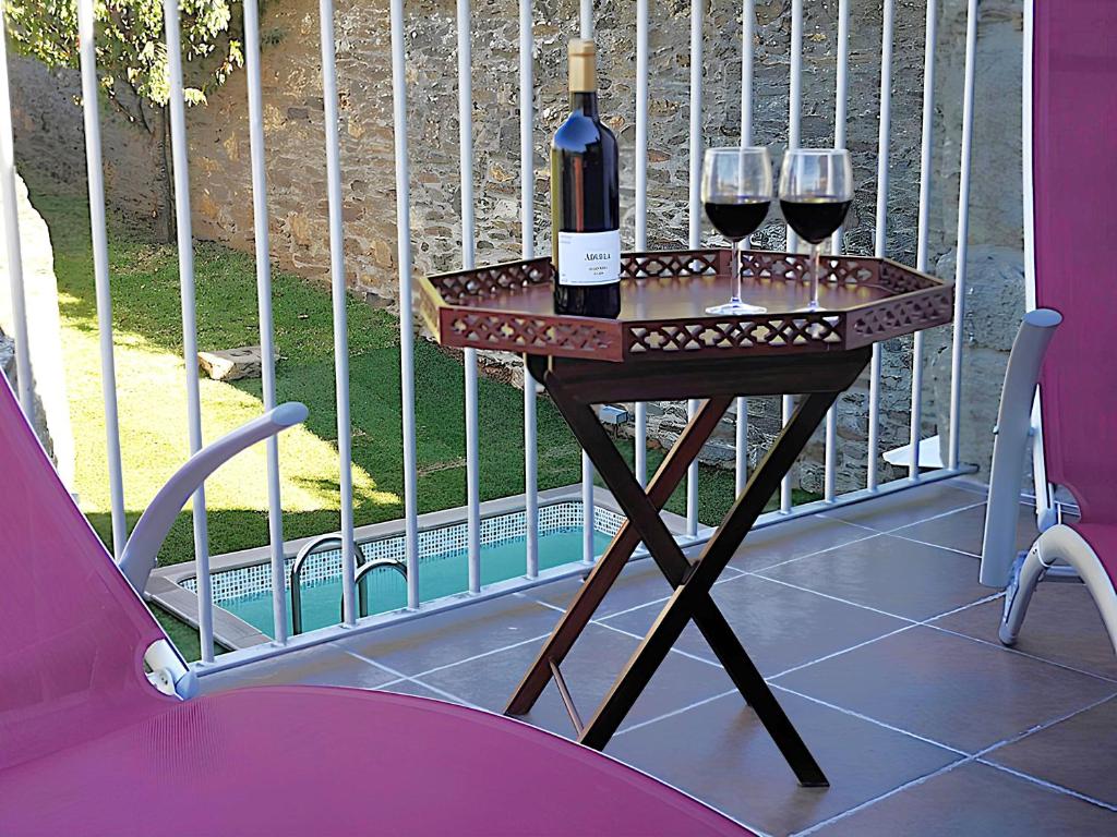 a table with two glasses of wine on a balcony at Sobreiro's Villa in Douro Valley in Mesão Frio