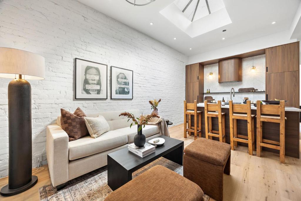 a living room with a couch and a table and a kitchen at The Brick Hotel - The Loft in Toronto