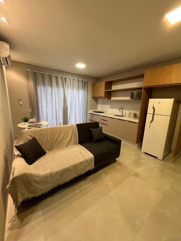 a living room with a couch and a kitchen at Atalaia Apart in Sinop