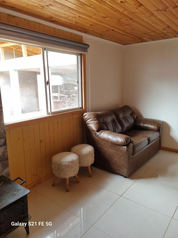 a brown leather couch in a room with a window at Casa de descanso in Paredones