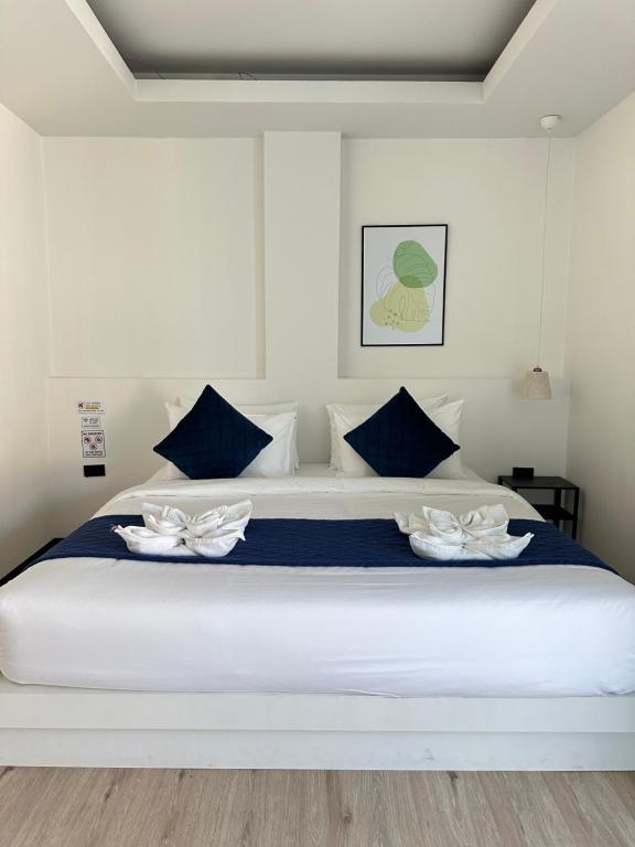 un grande letto bianco con due fiori bianchi sopra di Jellyfish Residence Patong a Patong Beach